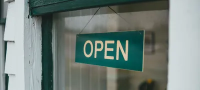 Green 'OPEN' sign in a restaurant shop window