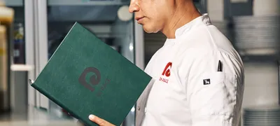 Chef reviewing a document closely in a commercial kitchen