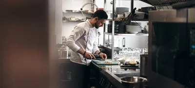 Chef working at a pass in a professional commercial kitchen