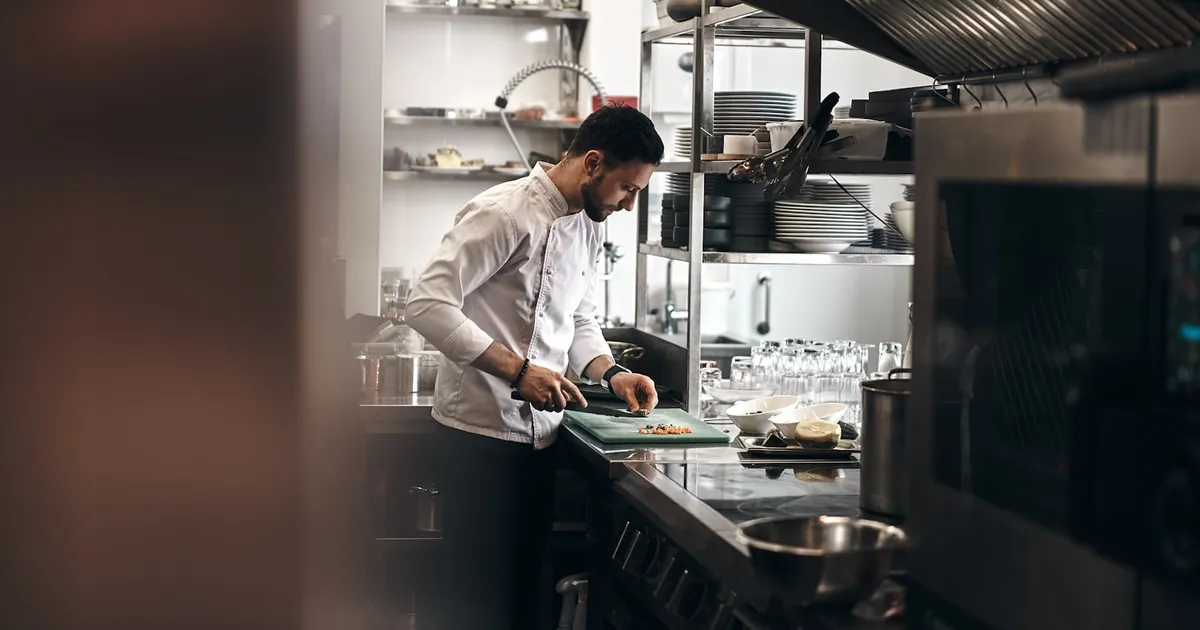 Chef working at a pass in a professional commercial kitchen